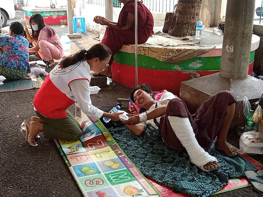 Mitarbeitende des Roten Kreuz in Myanmar verteilt Wasser an Erdbebenopfer