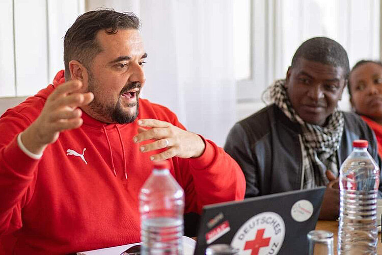 Enrique Rotkreuzmitarbeiter gestikuliert beim Sprechen