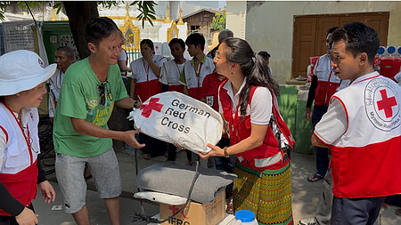 Ausgabe von Hilfsgütern (hier vom DRK) an die Bevölkerung durch das Myanmarische Rote Kreuz nach dem Erdbeben in diesem Jahr.