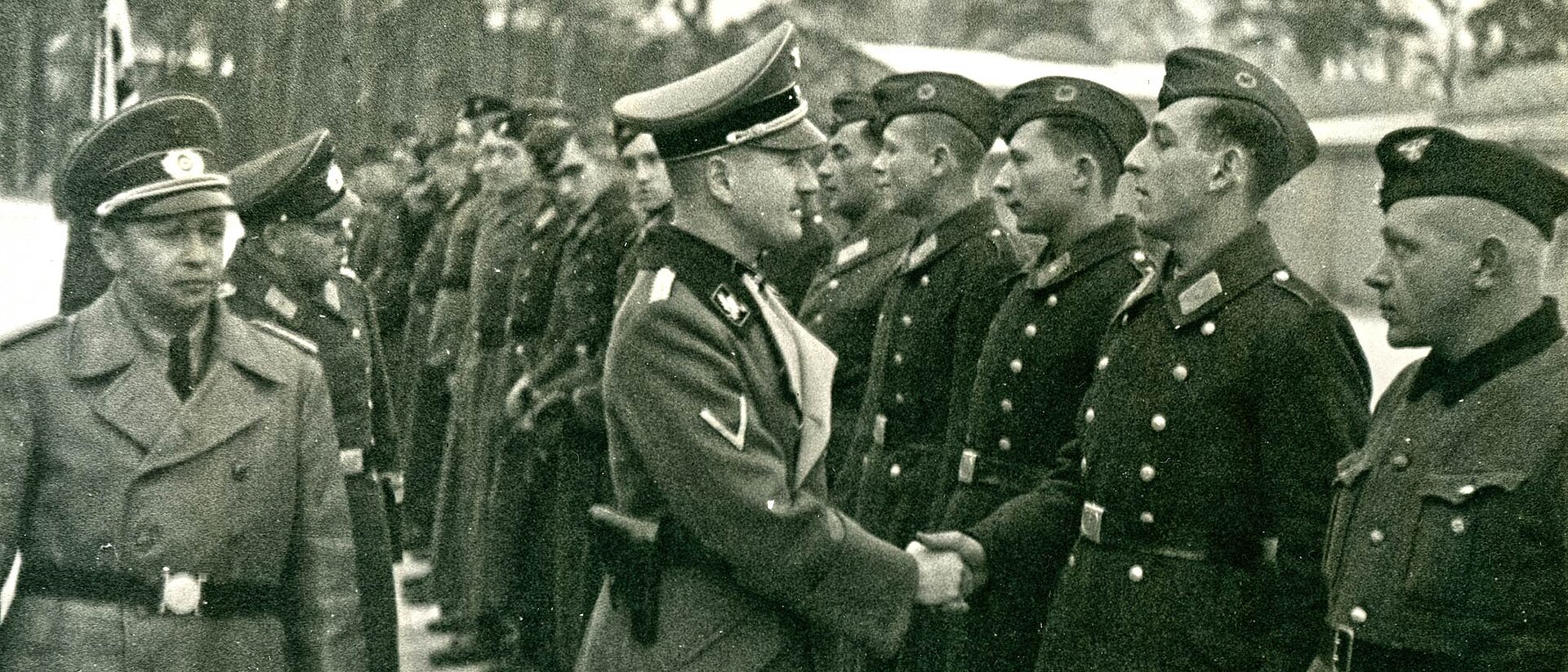 Begrüßung von Rückkehrern Mann in Uniform reicht Soldaten die Hand
