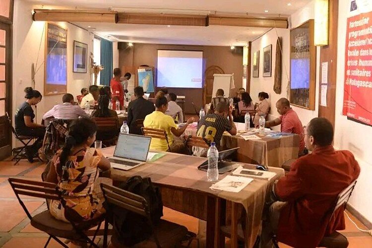 Training für Trainer Erwachsene an Tischen vor Präsentation