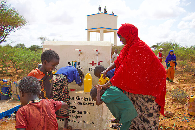 Frau mit Kindern an einem Brunnen in Somalia 