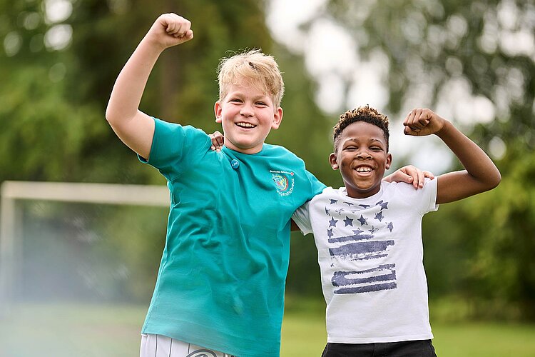 Zwei lachende Jungen machen Siegerfaust