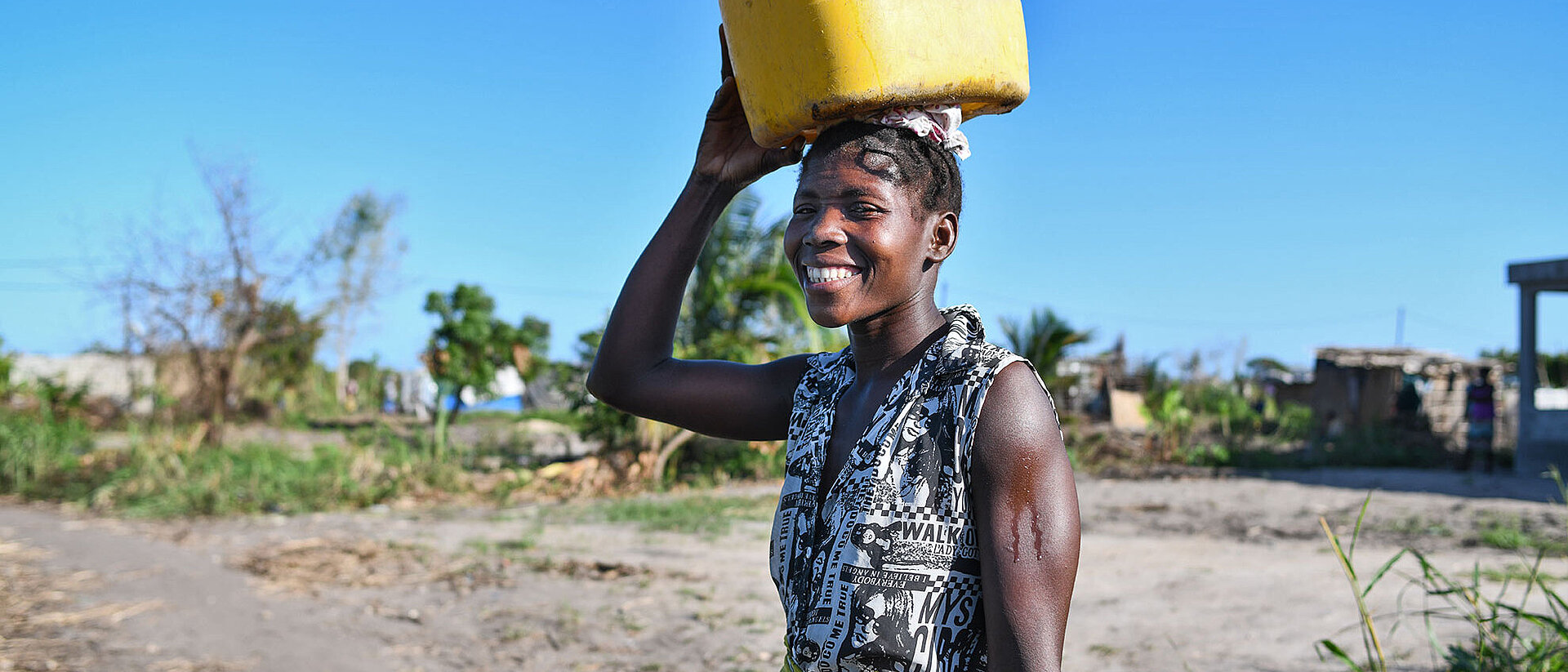 Woman in Mosambique carrying water can on head