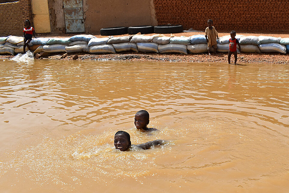 Kinder im Hochwasser Sudanesische Kinder schwimmen im Hochwasser