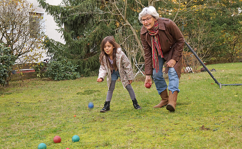 Wunschgroßeltern in Celle Ein Mädchen und eine Seniorin spielen zusammen auf einer Wiese