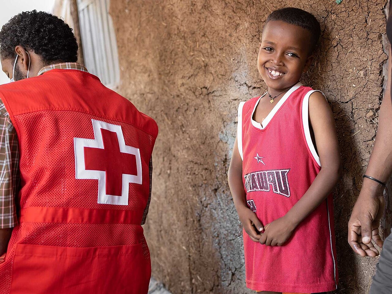 Smiling boy with Red Cross staff