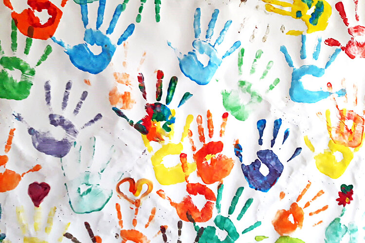 Viele bunte Handabdrücke auf Papier