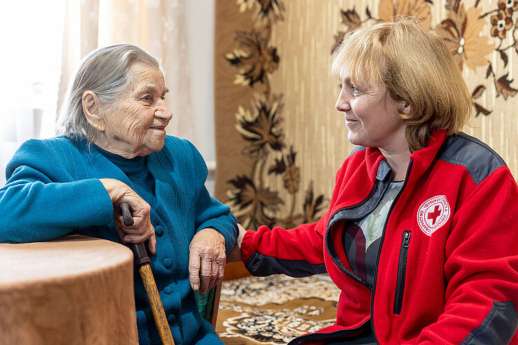 Seniorin mit Rotkreuzlerin