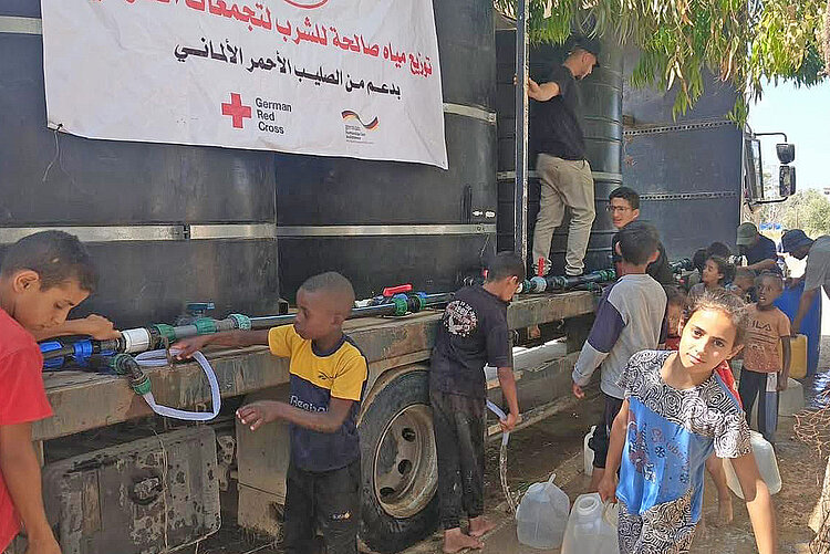 People next to water truck 
