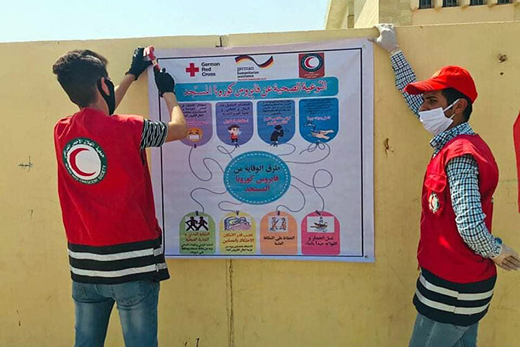 Sensibilisierung für Corona im Irak Irakische Rothalbmond-Helfer bringen Plakat an