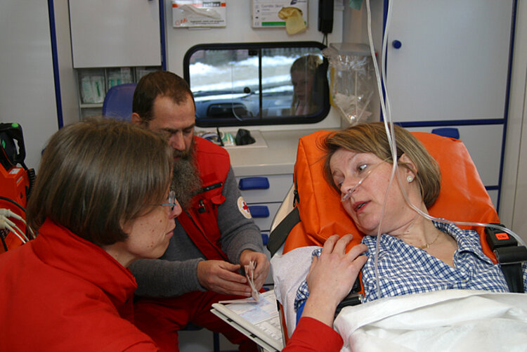 Der Rettungsassistent spricht mit der Patientin Gespräch mit Rettungsassistenten im Krankenwagen