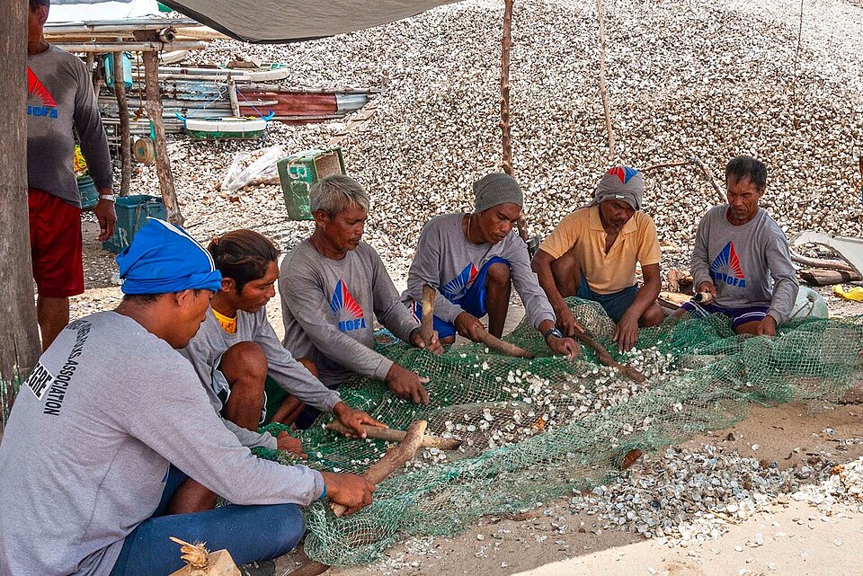 Men with fishing nets and shells