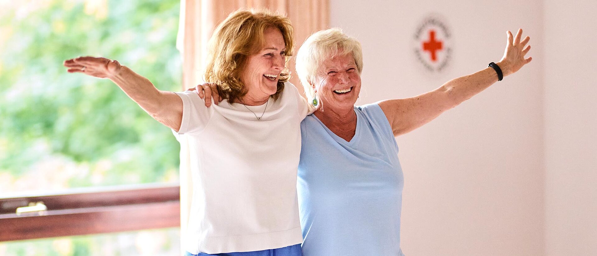 Zwei Frauen stehen mit angewinkeltem Bein