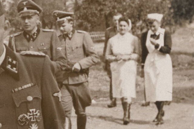 Rotkreuzschwester und NS-Schwester hinter SS-Männern