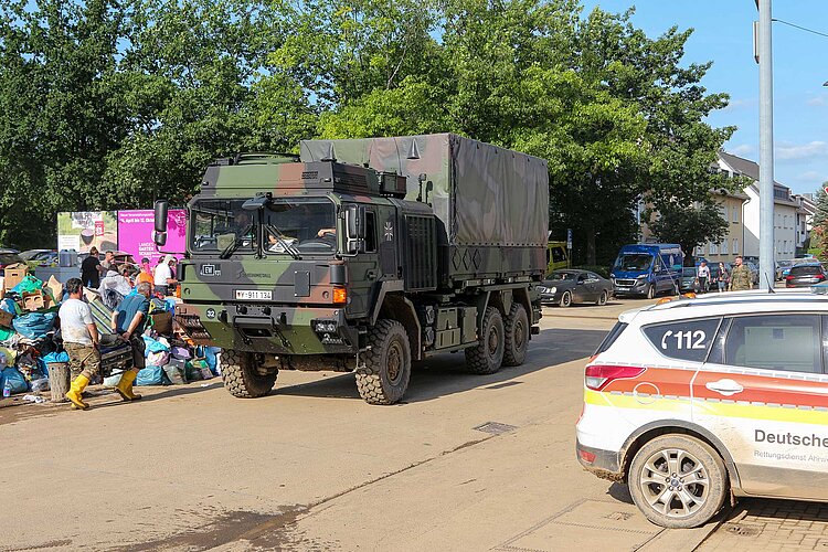 Hausrat, DRK-Fahrzeug und LKW der Bundeswehr