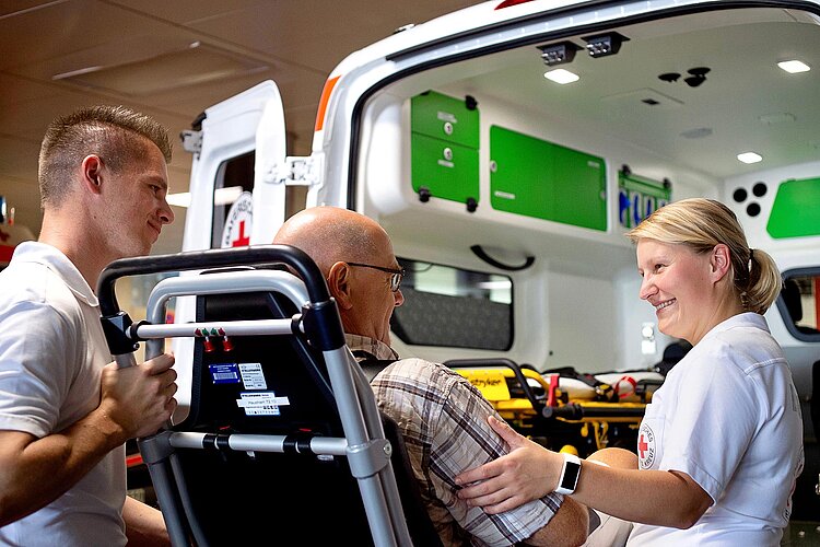 Krankentransport Rettungssanitäter mit Patienten am Rettungsfahrzeug