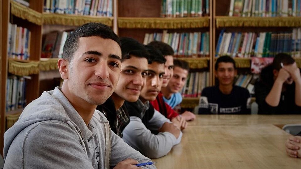 Beim Erste-Hilfe-Kurs Junge Männer lächeln am Tisch