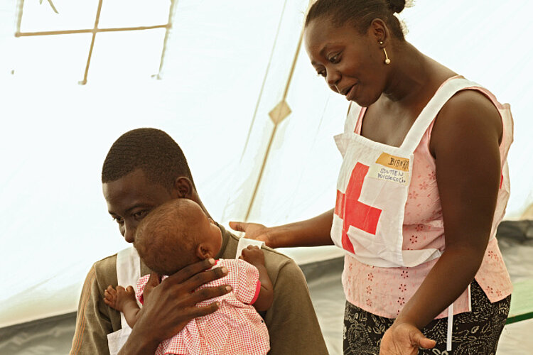 Red Cross helpers take care of a child GRC helpers take care of a child