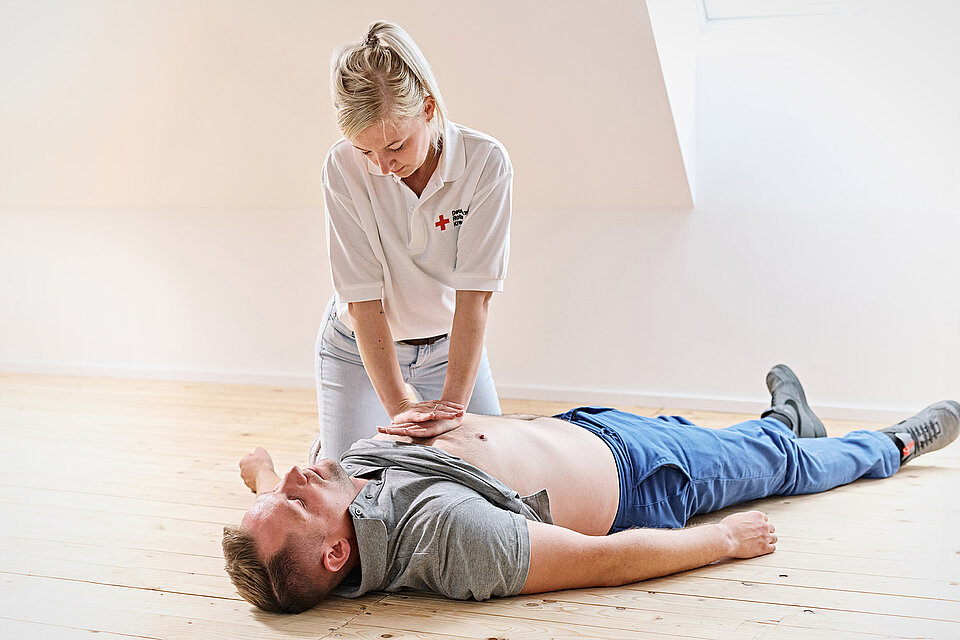 Lebensrettende Sofortmaßnahmen Frau führt Herzdruckmassage bei Mann durch