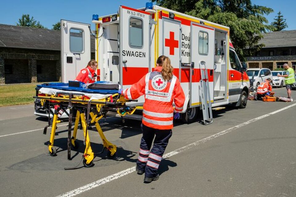 Rettungsdienst: Erste Hilfe beim Fahrradunfall (Dooring) Erste Hilfe beim Fahrradunfall, Versorgung des Unfallopfers durch Rettungssanitäter