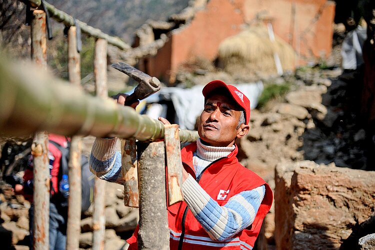 Red cross volunteer carrying trunk