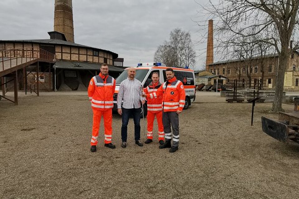 Die Fackel im Ziegeleipark Mildenberg Patrick Herrmann (Mitglied der SEE-Sanität), Ziegeleipark-Leiter Roy Lepschies, Hendrik Janz (Kreisbereitschaftsleiter DRK-Kreisverband Ostprignitz-Ruppin) und Ronny Schüler (Bereitschaftsleiter SEE-Sanität DRK-Kreisverband Gransee e.V.) mit der Fackel im Ziegelpark Mildenberg