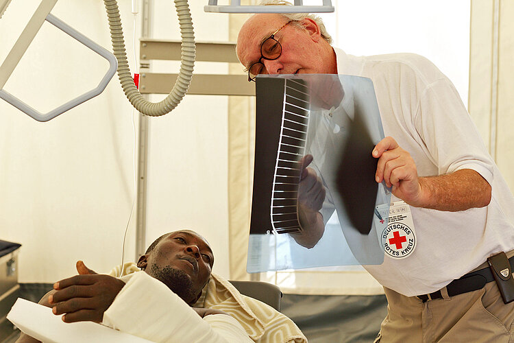 Doctor shows x-ray image to lying patient