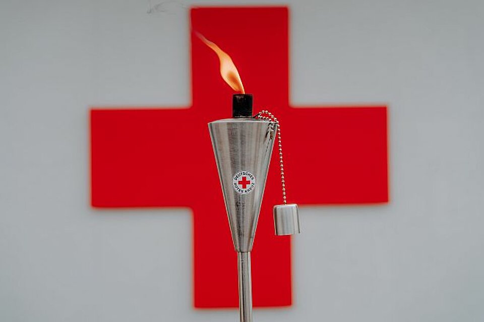 DRKFackel_RotesKreuzLogo DRK-Fackel vor Rotem Kreuz Logo