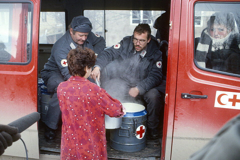 Erdbebenhilfe in Armenien DRK-Helfer geben warme Mahlzeit an Frau aus