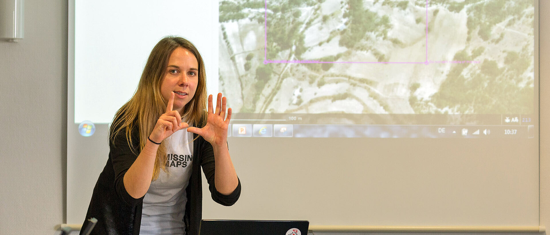 Mapathon Frau vor Karte erklärt etwas