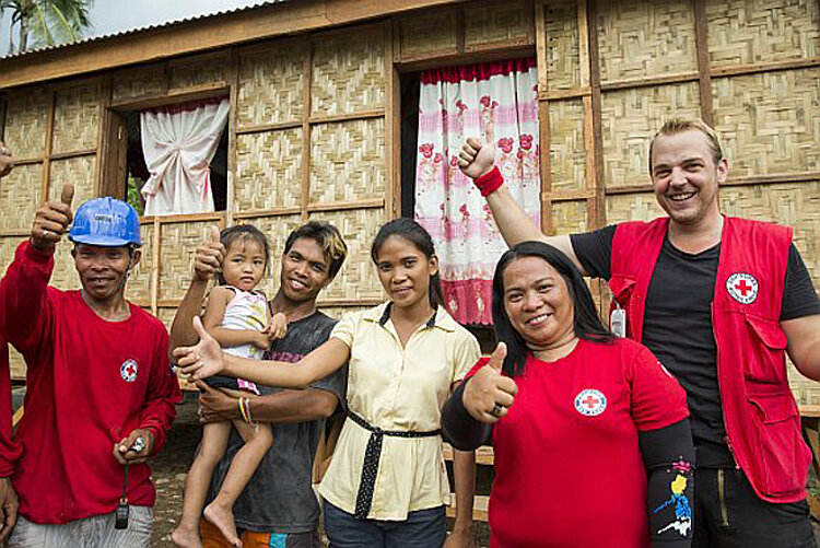 Volunteers and family in front of new house