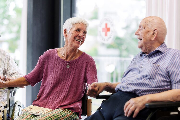 Therapeutin lacht mit Senior