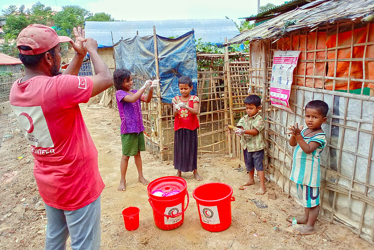 Volunteer and children washing their hands