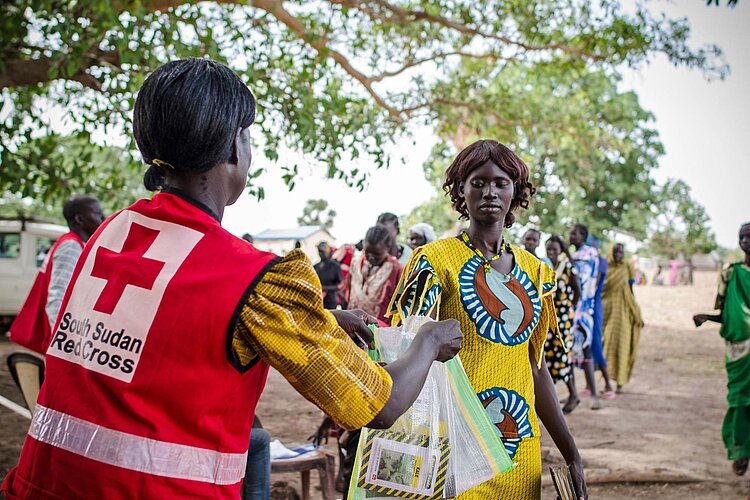 Rotkreuzhilfe in Südsudan Helferin übergibt Saatgut an Frau
