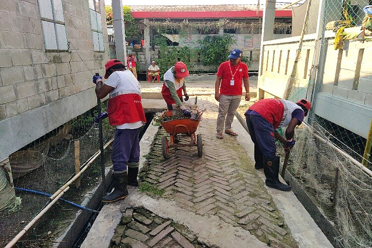 Helfer reinigen Abflüsse/Drainage im Camp
