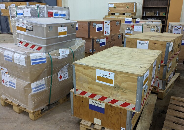 DRK-Hilfsgüter in einem Lagerhaus des Libyschen Roten Halbmonds. In einem Lagerraum lagern in Kartons verpackte Hilfsgüter des DRK auf Paletten.