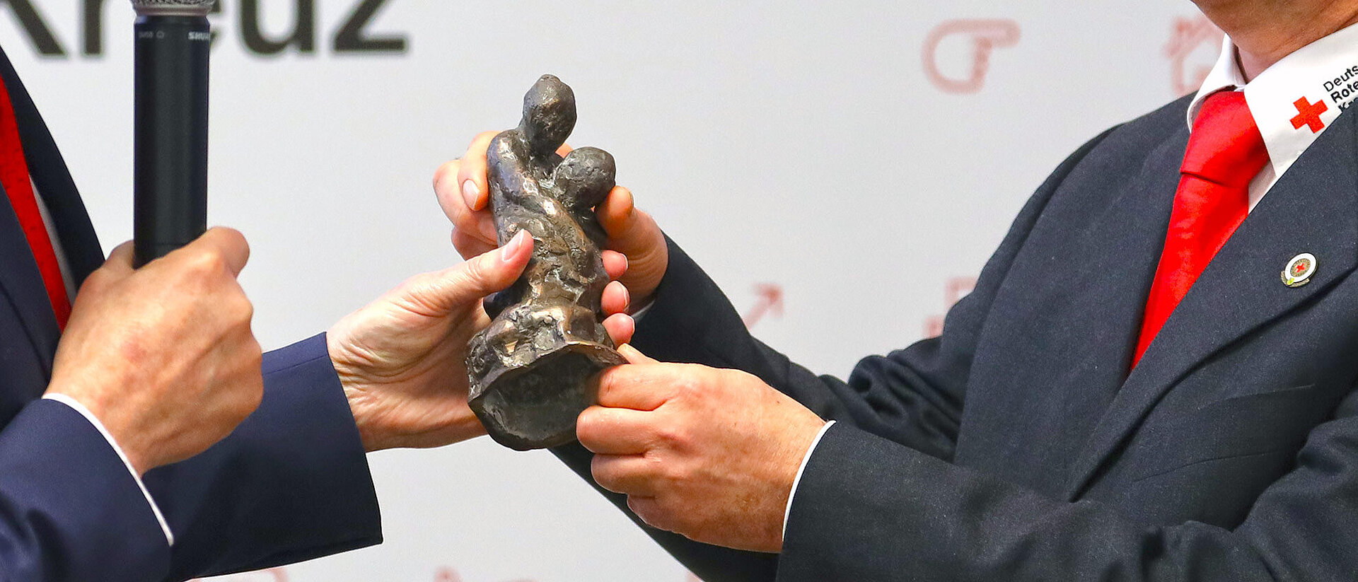 Castiglione-Preisverleihung Hände überreichen von Bruno Raetsch geschaffene Bronze-Skulptur des Castiglione-Preises