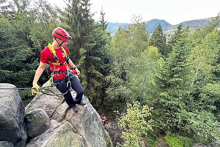Bergwacht-Helfer auf einem Felsen 
