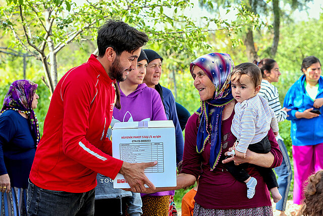 Volunteer hands over box to elderly woman